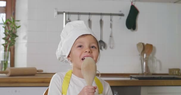 Little Girl Dressed Professional Cook Sings Kitchen Using Wooden Spoon — Stock Video