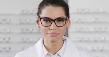 ağır çekim gözlük, optik Center'da kameraya bakıyor ve gülüyor beyaz kadın 