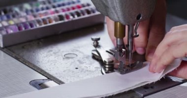 Yetenekli bir terzi dikiş makinesi ile İtalyan geleneğe göre beyaz bir kumaş dikiş bir giysi moda giyim yapmak için bir kalite kumaş diker. terzilik kavramı, moda, gelenek