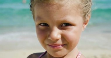 Deniz, güneş gözlüğü, deniz arka plan gülümseyen şirin kumsalda oynarken güzel küçük bir kız portre sarı kum ve mavi su. Konsept: çocuk, çocukluk, yaz, özgürlük, çocuk, Bebek.