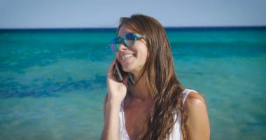 cep telefonu üzerinde denizde su konuşurken ve gözlüklü mutlu kadın video 