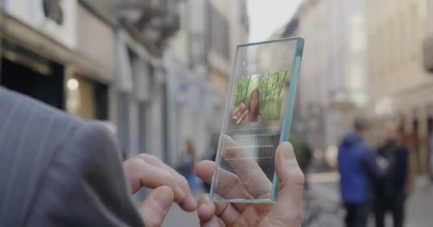 部分的なビデオビュー 未来的な 透明な携帯電話を使用して男 女性とのビデオ通話 — ストック動画