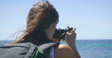 ağır çekim video turist kadının su deniz fotoğraflarını fotoğraf makinesi ile 