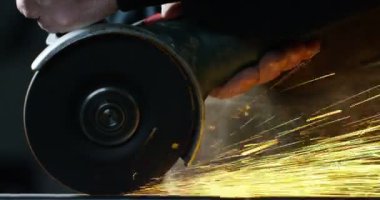 Demirci ya da kaynakçı, çelik ve demiri son derece yavaş çekimde yüzeyi pürüzsüz hale getirmek için öğütüyor. Demirle değirmen tekerleği teması kıvılcımlara neden oluyor. İş, çilingir endüstrisi, çilingir endüstrisi..