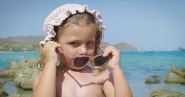 美丽的小女孩在海上玩的肖像 可爱的微笑在巴拿马 防晒霜 背景的海水和岩石 — 图库视频影像