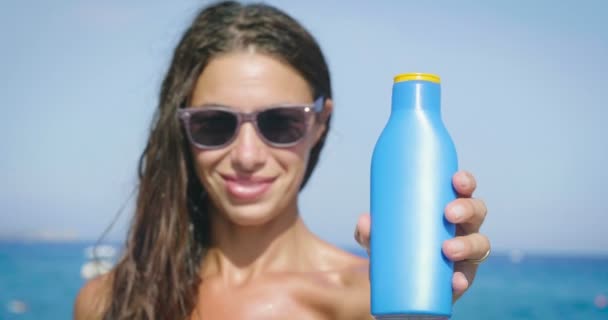 Vídeo Mujer Gafas Mostrando Crema Protector Solar Mar — Vídeo de stock