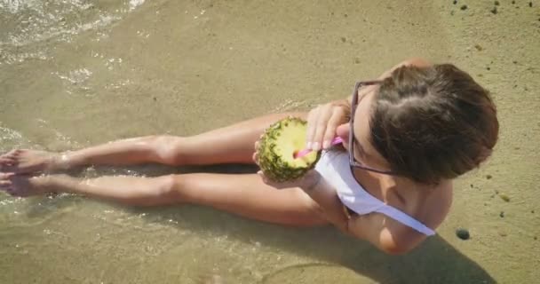 Vídeo Mujer Disfrutando Jugo Piña Playa Arena Vista Superior — Vídeos de Stock