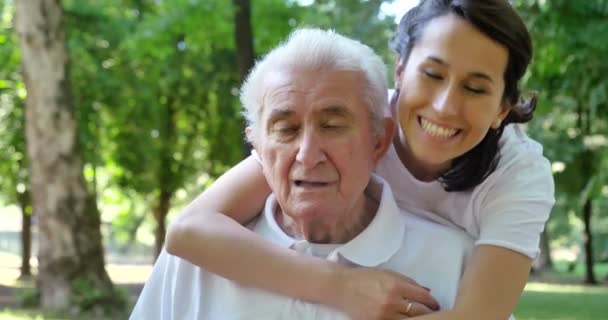 video-ból gondozó nővér ölelgetés nyugdíjas ember parkban
