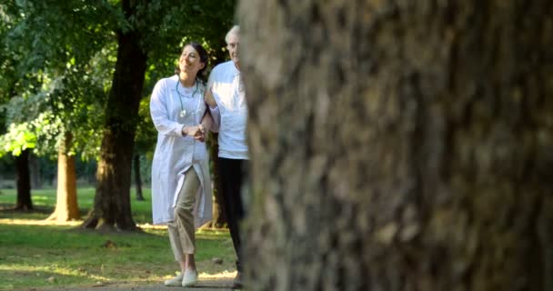 Video Van Verzorger Verpleegkundige Met Oudere Man Wandelen Park — Stockvideo