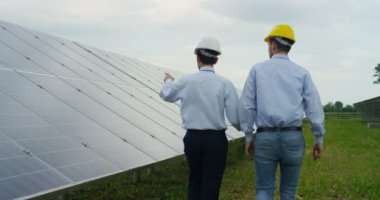 Arkadan görünüm, güneş panelleri yürüme ve konuşma, güneş enerjisi jeneratörleri iki adam ağır çekim video