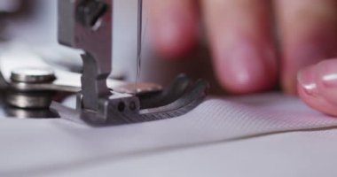 Yetenekli bir terzi dikiş makinesi ile İtalyan geleneğe göre beyaz bir kumaş dikiş bir giysi moda giyim yapmak için bir kalite kumaş diker. terzilik kavramı, moda, gelenek