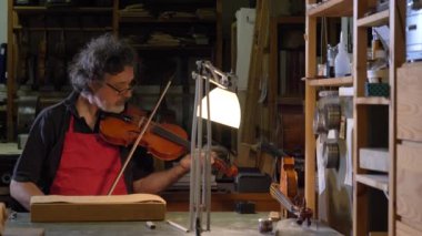 Profesyonel keman asıl kendi elleri ile bir keman yapar, kullanan bir temiz ağaç Ladin, çam, Gözlük, uçaklar, dizeleri tunes. Konsept: manevi enstrüman, el yapımı, sanat, müzik, melodi, ses.