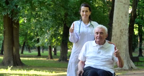 Vídeo Cuidador Enfermeira Com Pensionista Homem Gesticulando Polegares Parque Olhando — Vídeo de Stock