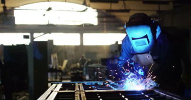 .Bir demirci veya Kaynakçı, kaynak çelik ve demir, aşırı yavaş hareket onun kaynakçı ile. Kaynakçı kıvılcımlar gözlerinizi korumak için bir maske kullanır. kavram: Manuel çalışma, demirci, sanayi, Kaynakçı