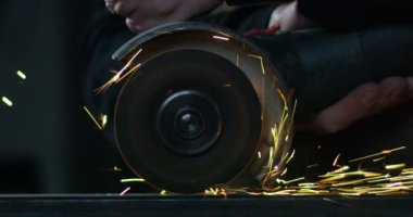 Demirci ya da kaynakçı, çelik ve demiri son derece yavaş çekimde yüzeyi pürüzsüz hale getirmek için öğütüyor. Demirle değirmen tekerleği teması kıvılcımlara neden oluyor. İş, çilingir endüstrisi, çilingir endüstrisi..