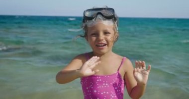 Denizde yüzme için maskeli gülümseyen şirin oynayan güzel küçük kız
