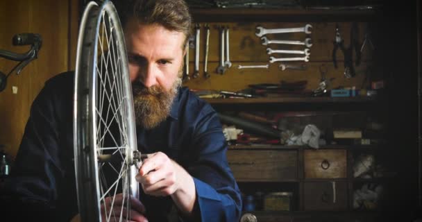 自転車の車輪を修理するひげを生やした白人男性のビデオ — ストック動画