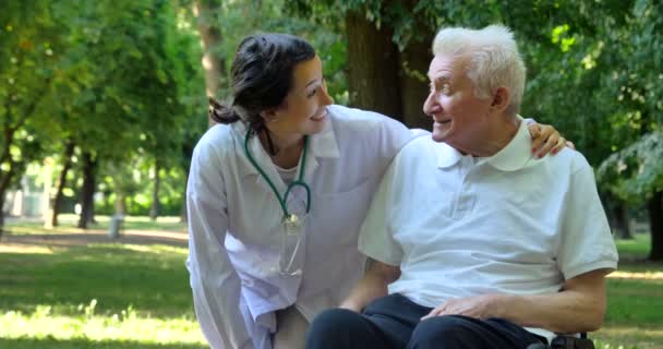 Video Van Verzorger Verpleegkundige Met Gepensioneerde Man Praten Glimlachen Park — Stockvideo