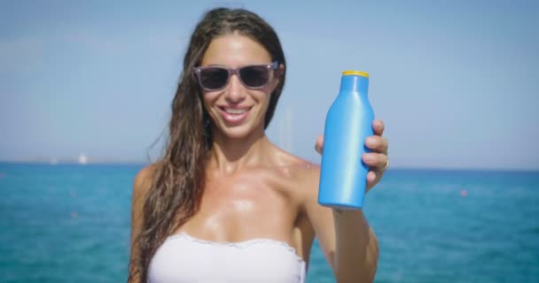 Vídeo Mujer Gafas Mostrando Crema Protector Solar Mar — Vídeo de stock