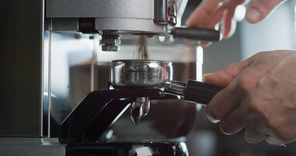 Macro of the hands of a barman while he is making coffee with the coffee machine, in a bar. Concept: macro, bar, breakfast