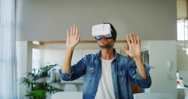 Oturma odasında vr gözlük kullanan yakışıklı adam portresi. Yenilik teknoloji, yaşam biçimi, eğlence kavramı.