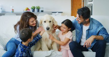 Bir köpekle birlikte oturma odasında eğleniyor mutlu aile portresi. Mutlu aile, hayvanlar, sevgi kavramı çocukluk
