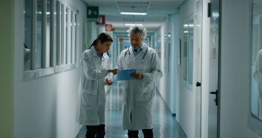 Doktor ve hemşire hastane koğuşunda yürüyüş sırasında onun tedavisi için gelecekteki tavsiye için bir hasta tanısında tartışıyor. Tıp, teknoloji, sağlık ve insan, hastane kavramı