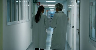 Doktor ve hemşire hastane koğuşunda yürüyüş sırasında onun tedavisi için gelecekteki tavsiye için bir hasta tanısında tartışıyor. Tıp, teknoloji, sağlık ve insan, hastane kavramı