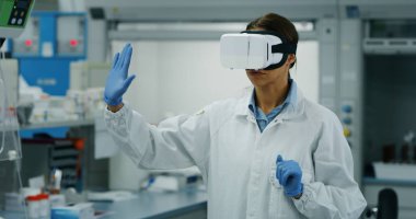 Fütüristik araştırmacı laboratuvarda araştırma sonuçlarını görüntülemek için hologram grafikleriyle artırılmış gerçeklik vr gözlük kullanarak portresi. 8 k'dan fazla vurdu. Fütüristik tıp ve bilim kavramı