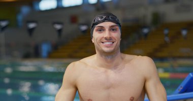 Portre profesyonel yüzücü gülümseyen, yüzme havuzunda sonuçları memnun. Spor, rekabet, fitness kavramı.