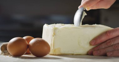 Bir şef bukleler tereyağı bir profesyonel mutfakta bir pasta yapmak için hazırlar. Kavramı: tereyağı, tatlılar, Şef.