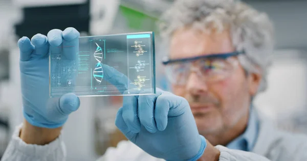 Portrait of futuristic researcher using the augmented reality screen with hologram graphics for viewing results of his research in laboratory. Shot in 8K. Concept of futuristic medicine and science