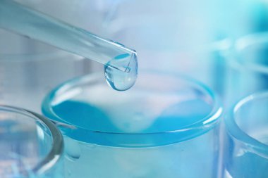 Fütüristik bir laboratuvarda bir bilim adamı bir pipet ile Dna ve test tüpleri molekülleri ayıklamak için renkli bir sıvı analiz eder. Kavram: araştırma, biyokimya, üstün teknoloji, augmented reality