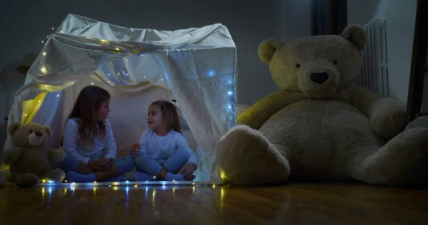 つの小さな女の子の姉妹 キッズ 懐中電灯を照らすライトが付いて再生の家で暗闇の中で物語を読みます コンセプト — ストック写真