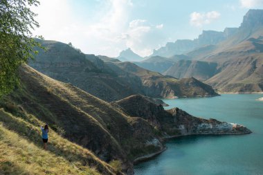 Kadın, Elbrus bölgesindeki güzel gölün tadını çıkarıyor.