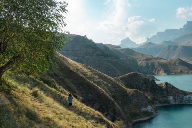 Kadın, Elbrus bölgesindeki güzel gölün tadını çıkarıyor.