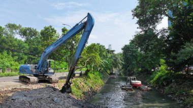 Şehirdeki yolda kazıcı çalışıyor.