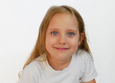 Mavi gözlü ve açık renk saçlı neşeli genç kız beyaz bir tişört giyiyor, temiz beyaz bir arkaplanda poz veriyor. Aile, eğitim ya da yaşam tarzı projeleri için mükemmel.