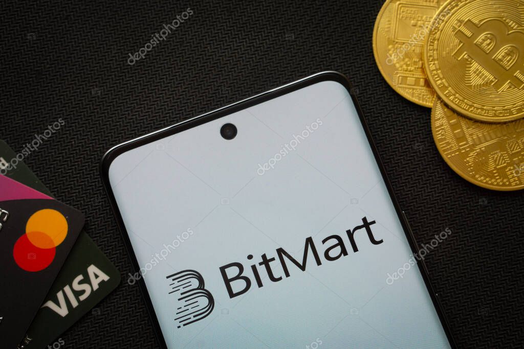 Dhaka, Bangladesh- 06 Sep 2025: Smartphone displaying Bitmart logo surrounded by Bitcoin coins and payment cards.