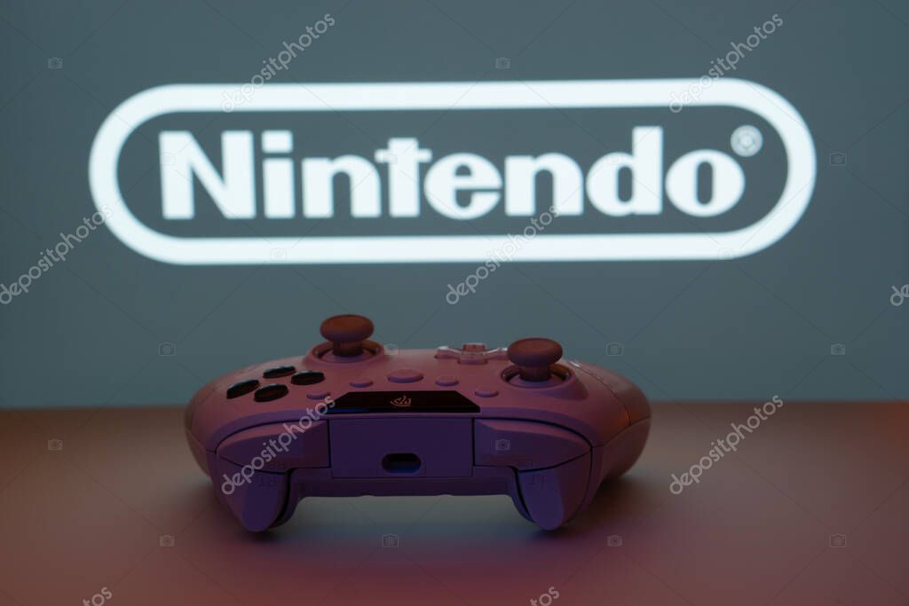 Dhaka, Bangladesh- 15 July 2025: A close-up of a gamepad with the nintendo seen on screen in the background.