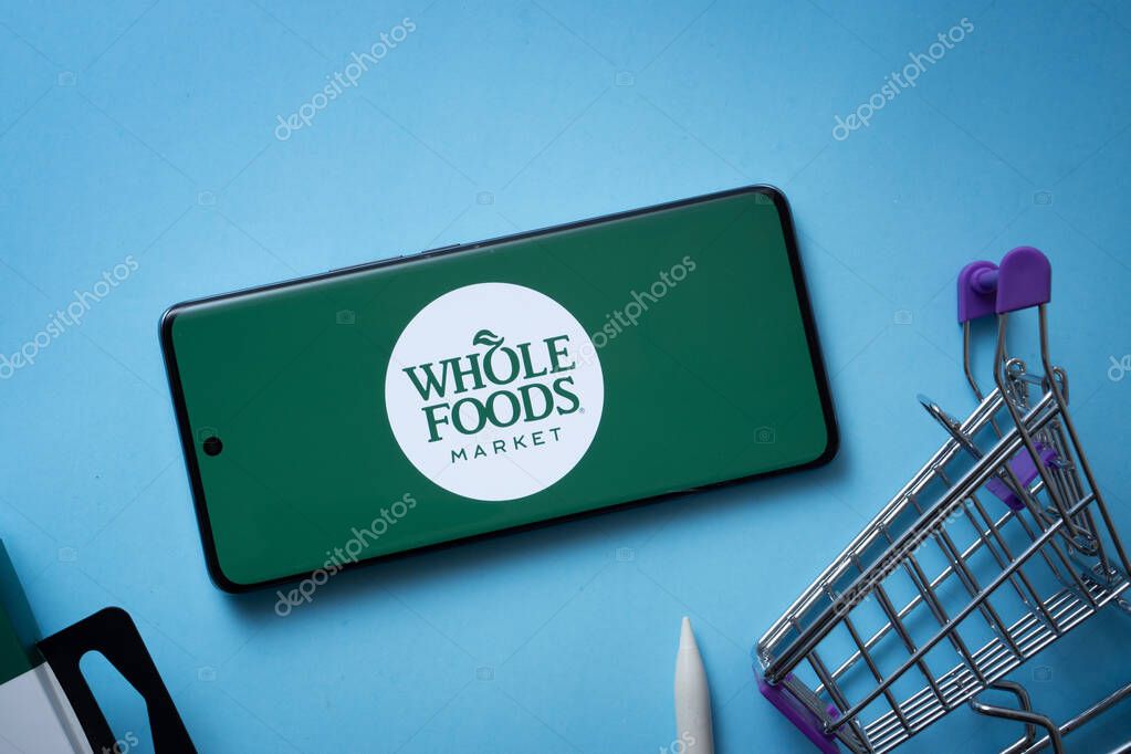 Dhaka, Bangladesh- 03 July 2025: Smartphone displaying Whole Foods Market logo with shopping cart on a blue background.
