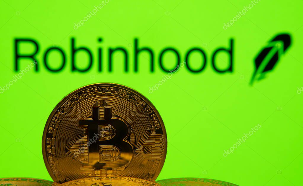 Dhaka, Bangladesh- 20 Sep 2025: Close-up of Bitcoin coins with the Robinhood logo visible on a screen in the background.