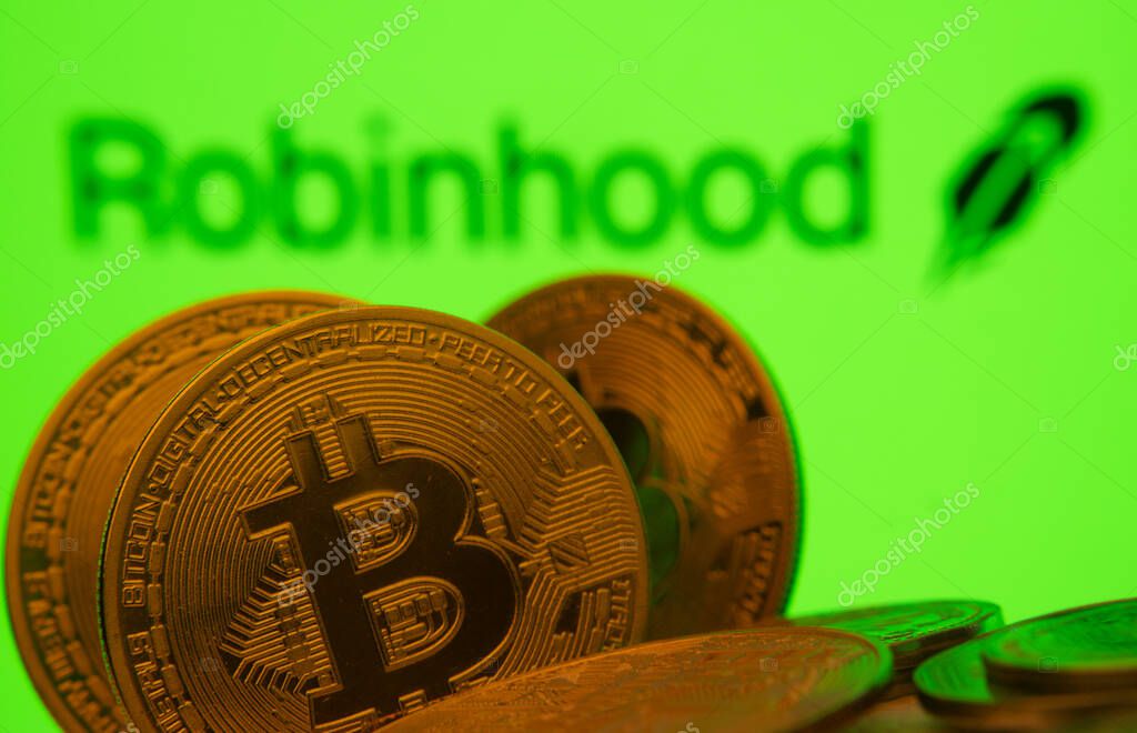 Dhaka, Bangladesh- 20 Sep 2025: Close-up of Bitcoin coins with the Robinhood Markets logo visible on a screen in the background.