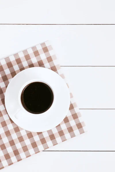 Xícara de café com guardanapo no fundo branco woodetn. Vista superior, espaço de cópia . — Fotografia de Stock