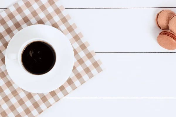 Xícara de café com macaroons em guardanapo e fundo branco. Vista superior, espaço de cópia . — Fotografia de Stock