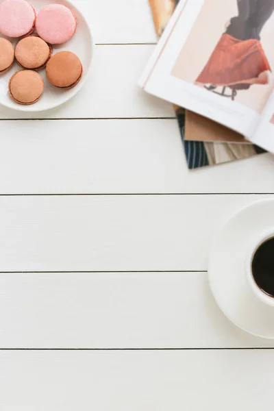 Xícara de café preto em uma mesa de madeira branca com revista de moda e macaroons. Processamento de autor, efeito de filme . — Fotografia de Stock