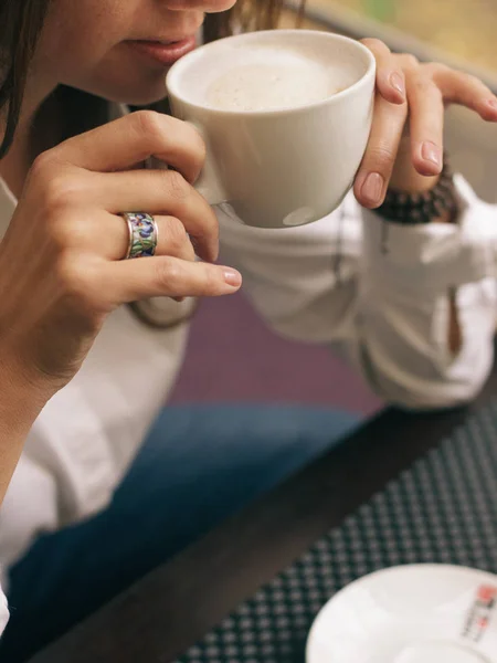 Mujer con hermosas manos está bebiendo café en la cafetería. Cappuccino de cerca en taza blanca, imagen con efecto de película y procesamiento de autor . —  Fotos de Stock