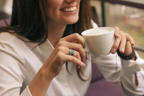 Güzel elli kadın kafede kahve içiyor. Beyaz bardakta kapuçino, film efektli görüntü ve yazar işleme.