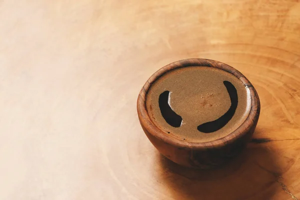 Ahşap arka planda ahşap fincan siyah kahve. Kahverengi bardakta espresso, film efekti ve yazar işleme ile görüntü.