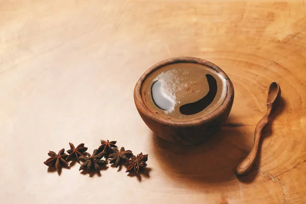 Caffè nero in tazza di legno con cucchiaio di legno e anice stellato su sfondo di legno. Copia-spazio e elaborazione dell'autore . — Foto Stock